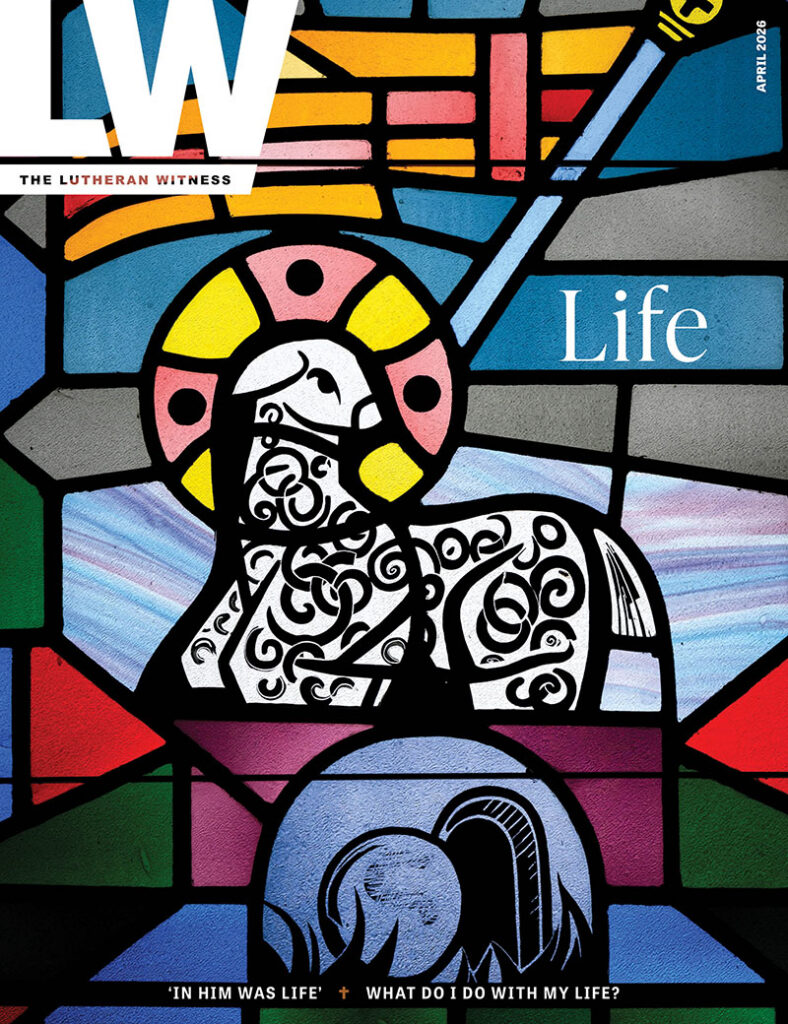 The Lutheran Witness — April 2026 issue — Life — On the Cover: At Trinity Lutheran Church, Bellingham, Minn., a stained glass window features the traditional Agnus Dei symbol, the “Lamb of God” who is the atoning sacrifice for our sins. The Lamb bears a banner representing His victory over death and His eternal reign. Below Him is the tomb that once held Him, now open and empty. He has risen, and, in Him, you too will rise!