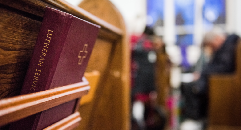 'Lutheran Service Book" hymnal sits in a church pew rack.